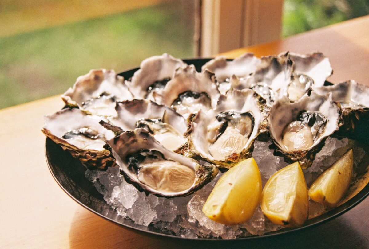 Photograph of open oysters on a plate with lemon